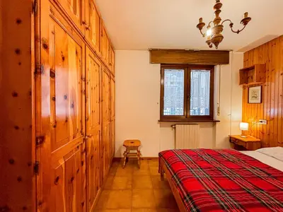 a bedroom with a bed and a window at Appartamenti Des Alpes in Canazei