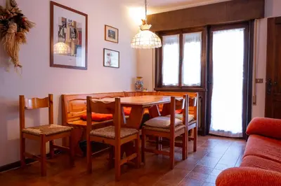 a dining room with a table and chairs at Appartamenti Des Alpes in Canazei