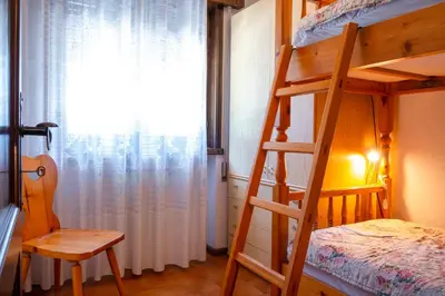 a bedroom with a bunk bed and a window at Appartamenti Des Alpes in Canazei
