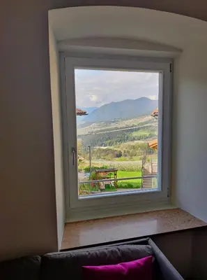 a window with a view of a table and mountains at Casa vacanze Da Bianca in Castelfondo
