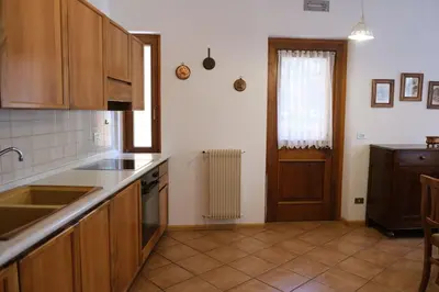 a kitchen with wooden cabinets and a sink and a window at Apartments Anny in Canazei