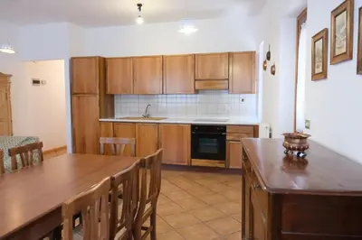 a kitchen with wooden cabinets and a wooden table at Apartments Anny in Canazei