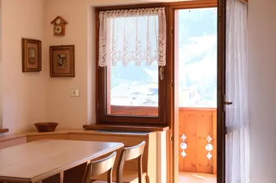 a dining room with a table and a window at Apartments Anny in Canazei
