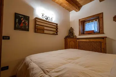 a bedroom with a white bed and a window at Casa Lacedel 1, on ski slopes in Cortina dʼAmpezzo