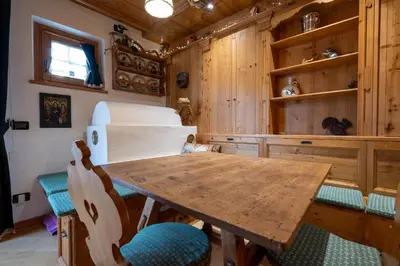 a dining room with a wooden table and chairs at Casa Lacedel 1, on ski slopes in Cortina dʼAmpezzo
