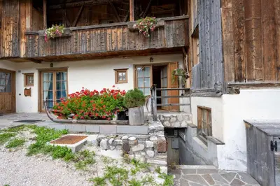 a house with flowers on the side of it at Casa Lacedel 1, on ski slopes in Cortina dʼAmpezzo