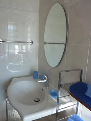 a bathroom with a white sink and a mirror at Appartamenti Valpinoi in Santa Cristina in Val Gardena