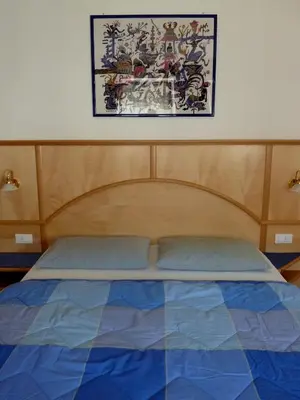 a bedroom with a bed with a wooden head board at Appartamenti Valpinoi in Santa Cristina in Val Gardena