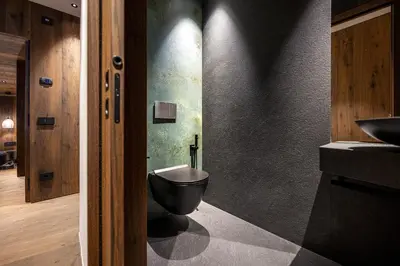 a bathroom with a black toilet and a sink at Chalet Urela Luxury Apartment in Santa Cristina in Val Gardena