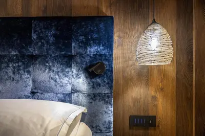 a bedroom with a bed and a blue wall at Chalet Urela Luxury Apartment in Santa Cristina in Val Gardena