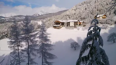a lodge in the mountains with snow on the ground at Vitroler Hof in Rodengo