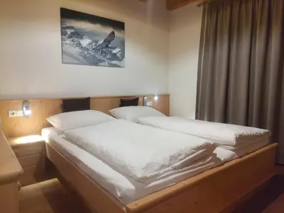 a bedroom with a large bed with white sheets at Vitroler Hof in Rodengo