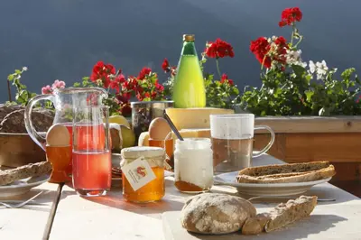 a table with food and drinks and bread on it at Vitroler Hof in Rodengo