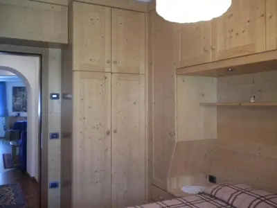 a room with wooden cabinets and a bed at B&B fam. Ausermiller in Castello di Fiemme