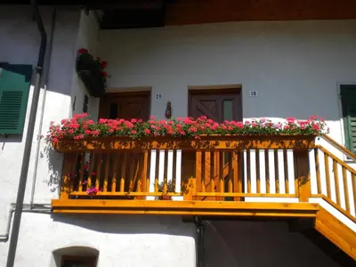 a wooden balcony with flowers on a house at B&B fam. Ausermiller in Castello di Fiemme