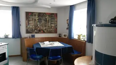 a dining room with a table and blue chairs at B&B fam. Ausermiller in Castello di Fiemme