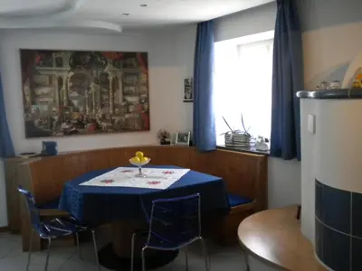 a dining room with a blue table and chairs at B&B fam. Ausermiller in Castello di Fiemme