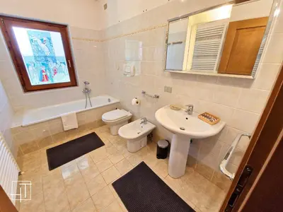 a white bathroom with a sink and a toilet and a sink at HT - Ciasa Dahu Cortina Escape in San Vito di Cadore