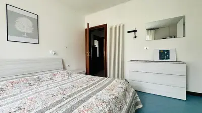 a bedroom with a bed in a room with two windows at Appartamento Margherita in Transacqua