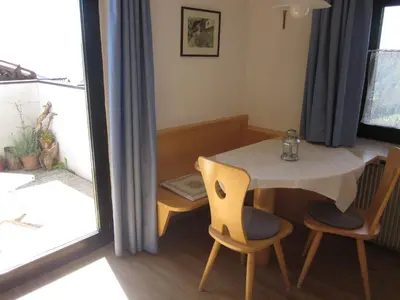 a small table and chairs in a room with a window at Gasthof zum Roessl in San Genesio Atesino