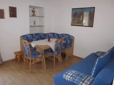 a living room with a table and a blue couch at Gasthof zum Roessl in San Genesio Atesino