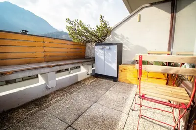 a balcony with a bench and a table and a plant at Casa Franz in Val di Fassa by Zoom In Earth in Mazzin