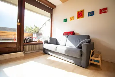 a living room with a couch and a window at Casa Franz in Val di Fassa by Zoom In Earth in Mazzin