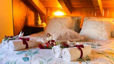 a bed with towels and christmas decorations on it at Chalet Stravedo by Ca-Sa Check in Villanova