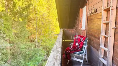 a porch with a chair with a blanket on it at Chalet Stravedo by Ca-Sa Check in Villanova