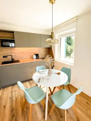 a kitchen and dining room with a white table and chairs at Amontis Dolomites in Siusi