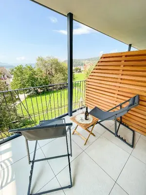 a balcony with a chair and a table and a view at Amontis Dolomites in Siusi