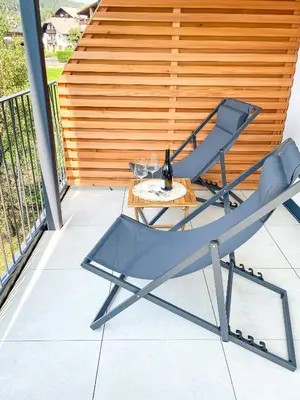 a chair and a table on a patio at Amontis Dolomites in Siusi
