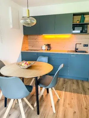 a kitchen with a wooden table and blue cabinets at Amontis Dolomites in Siusi