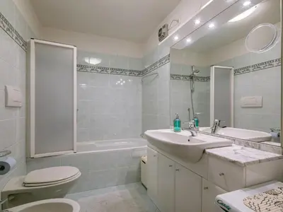 a bathroom with a sink and a wooden door at Apartment Condominio al Parco-11 by Interhome in Canazei