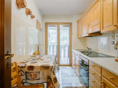 a kitchen with wooden cabinets and a counter top at Apartment Condominio al Parco-11 by Interhome in Canazei