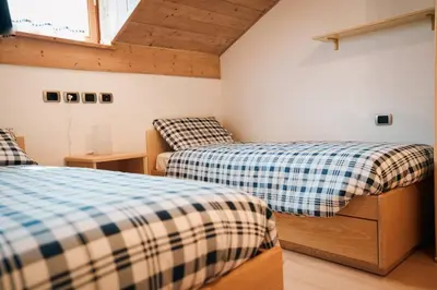 a bedroom with two beds and a window at Zirmo - Your nordic stay in Tesero