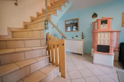 a living room with a staircase and a tv at Zirmo - Your nordic stay in Tesero