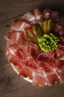 a pizza with bacon and broccoli on a table at Pension Gasthof Haselstaude in San Leonardo in Passiria
