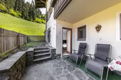 two chairs on the patio of a house at Pension Gasthof Haselstaude in San Leonardo in Passiria