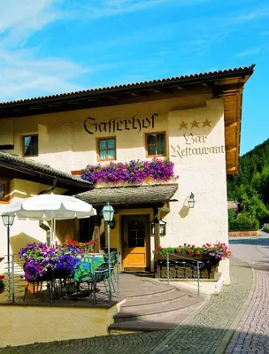 a building with a table and chairs in front of it at Gasthof Gasserhof in Eggen