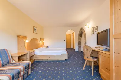 a hotel room with a bed and a television at Gasthof Gasserhof in Eggen
