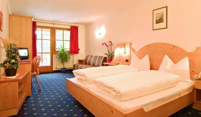 a hotel room with a bed and a living room at Gasthof Gasserhof in Eggen