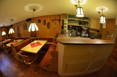 a restaurant with a bar and a table and chairs at Garni Ossi in Santa Cristina in Val Gardena