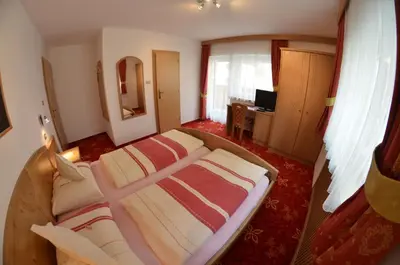 a bedroom with a large bed in a room at Garni Ossi in Santa Cristina in Val Gardena