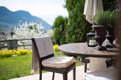 a table with a chair and a table with at Hotel Chalet Gravenstein in Tirolo