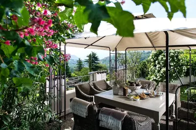 a patio with a table and an umbrella at Hotel Chalet Gravenstein in Tirolo