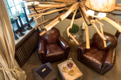 a living room with two leather chairs and a table at Hotel Chalet Gravenstein in Tirolo