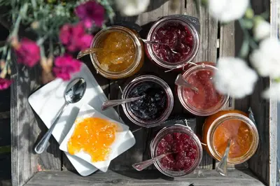 a table topped with jars of jam and jamospelospelospelospelospelospelospel at Hotel Chalet Gravenstein in Tirolo