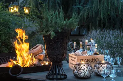 a table with a vase and a fire pit at Hotel Chalet Gravenstein in Tirolo