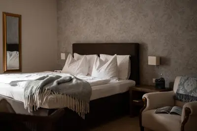 a hotel room with a bed and a chair at Hotel Chalet Gravenstein in Tirolo